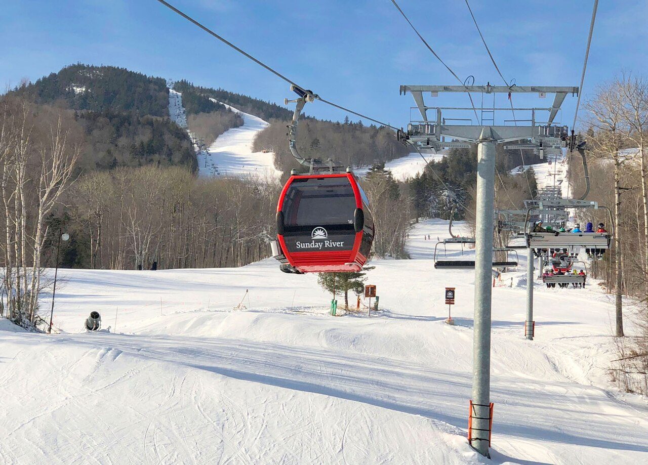 The Chondola lift at Sunday River with gondola cabins and chairs above a snowy slope