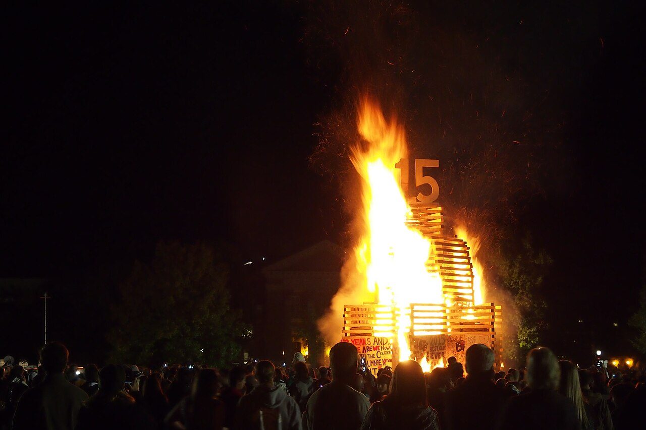 Crowd gathered around the Homecoming bonfire on the Dartmouth Green at night