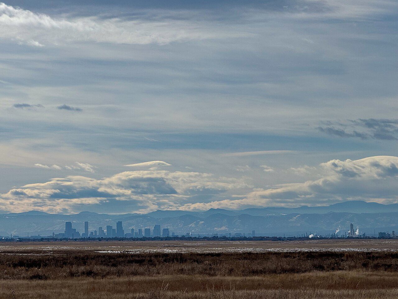 Denver skyline with the Front Range mountains behind, seen from Rocky Mountain Arsenal